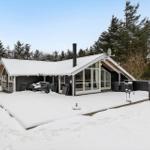 Snow-free terrace with seating area in front of modern wooden house.