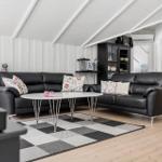 Two black leather sofas around a round table with a black-and-white rug.
