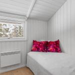 Bedroom with bed, window, and heater on the wall.