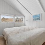 Bedroom with sloped ceiling, windows, and bed.