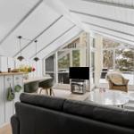 Living kitchen with dining area and fireplace. Large windows with snowy view.