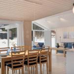 Dining area with wooden table and chairs, living area with sofa and stove