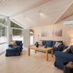 Living room with wooden ceiling, blue sofas, and fireplace