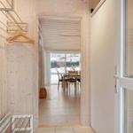 Hallway with coat rack and view into dining area with table and chairs.
