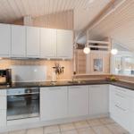 Kitchen with white cabinets, dark countertop, and wood paneling.