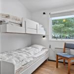 Room with bunk bed and chair by window