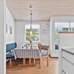 Dining area with table, chairs, and windows for views.