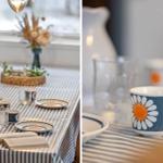 Table set with plates, mug, and candles. Vase with flowers and open book.