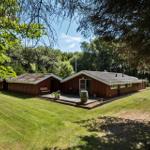 Red wooden house with terrace and garden under trees