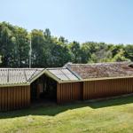 Wooden building with roof and woodpile in the garden