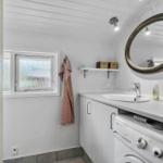 Bathroom with washing machine, mirror, and window