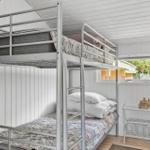 Room with bunk bed, window and small table.