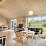 Living room with dining area, sofa, chairs, and large windows.