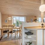 Kitchen with dining area, wood walls, and glass doors. Countertop, chairs, and table visible.