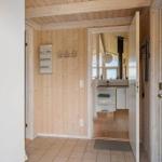 Entrance area with wooden wall and door to bathroom.