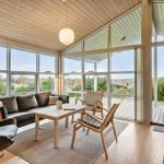 Living room with wooden ceiling, large windows, and view of the terrace.