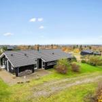 Black house with terrace and garden. View of forest and fields.