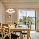 Dining room with wooden table, chairs, and view of balcony.