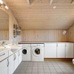 Bathroom with washing machine, dishwasher, and toilet