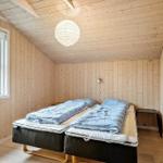 Room with two mattresses, wood walls and window. Ceiling with lamp.