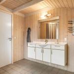 Bathroom with wooden walls, sink, and heater