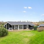 Modern wooden house with terrace, garden, and shed. Clear view of the field.