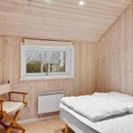 Schlafzimmer mit Bett, Stuhl und Fenster. Holzwände und Decke.