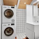Wohnung mit Waschmaschine und Trockner sowie Waschbecken und Spiegel.