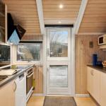 Küche mit Holzwänden, Arbeitsplatte und Tür zum Außenbereich.