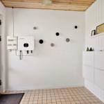 Entrance area with white wall, wooden ceiling, and tiled floor. A power storage unit is mounted on the wall.