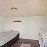 Bedroom with bed, globe, and white walls.