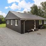 A dark brown wooden house with white windows and a terrace.