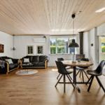 Living and dining area with wooden floor, sofa, dining table, and windows.