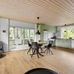 Kitchen with dining table, wooden floor, and wooden ceiling. Access to terrace.