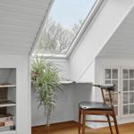 Dachgeschosszimmer mit Dachfenster, Pflanze, Stuhl und Glasfrontschrank.