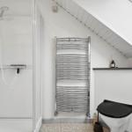 Dusche, Heizung und Toilette in einem Dachbodenbad.