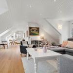 Wohn- und Essbereich mit Holzboden, Sofa und Fernseher