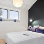 Schlafzimmer mit Bett, Fenster und Lampen.