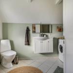 Badezimmer mit Toilette, Waschbecken und Waschmaschine.