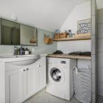 Waschmaschine neben Waschbecken und Spiegelfläche