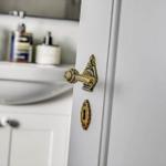 Tür mit goldenem Griff und Schlüsselloch im Badezimmer