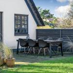 Terrasse mit Tisch und Stühlen vor einem Haus mit Schieferdach.
