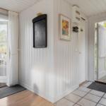 Entrance area with white walls, door to garden and balcony, map and picture on wall.