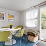 Dining room with green chairs, white table, and blue rug. Access to terrace.