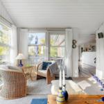 Living area with wicker chairs, large windows, and garden view.