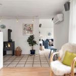 Room with fireplace, plant, and seating near window.