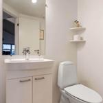 Badezimmer mit Waschbecken, Spiegel, Toilette und Handtuch.