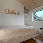 Schlafzimmer mit Bett, Fenster und Stuhl