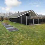 Schwarzes Ferienhaus mit Garten und Grillplatz.