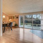 Großes Wohnzimmer mit Esstisch, Kamin und Terrasse